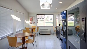 A room with a large window, a ceiling fan, and a vending machine. - Americas Best Value Inn Heath Newark (Heath)