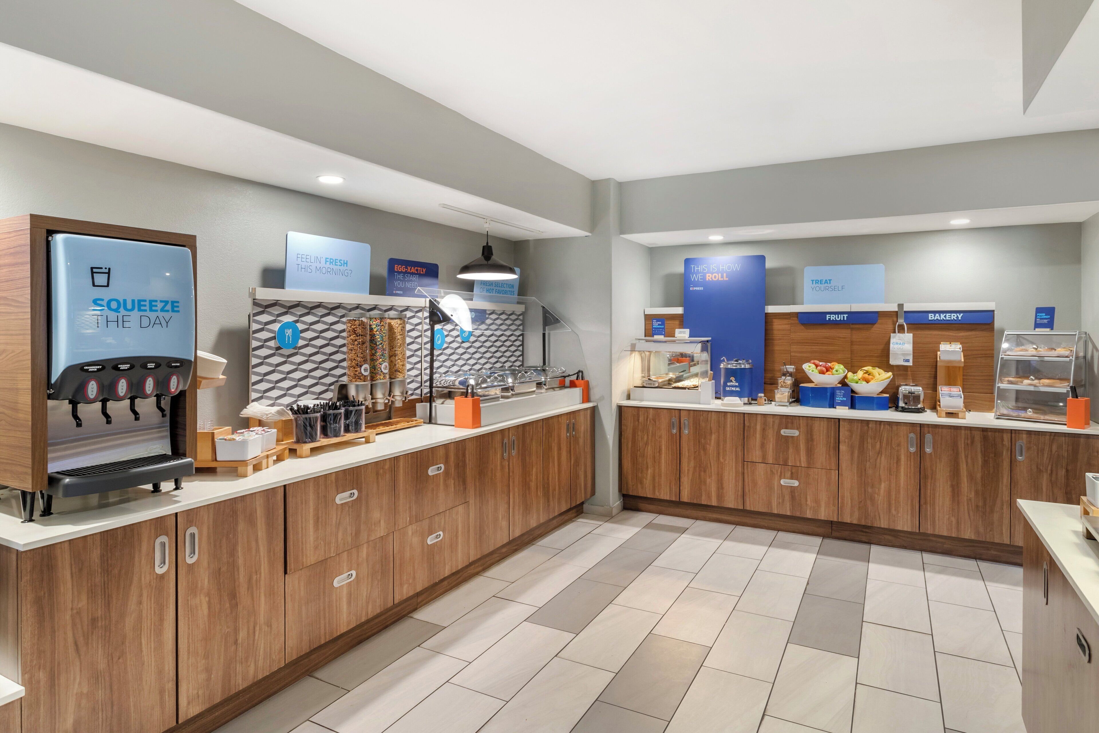 A modern cafe with a coffee machine, fruit and bakery display, and a sign reading "FEELIN' FRESH THIS MORNING?"