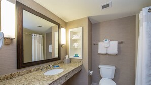 A bathroom with a granite countertop, a sink, a mirror, a toilet, and a shower curtain. - Holiday Inn Express Hotel & Suites Auburn by IHG (Auburn)