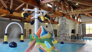 An indoor swimming pool with a colorful fish slide and a stone pillar. - SouthShore Hotel on Lake Bemidji, Trademark Coll by Wyndham (Bemidji)