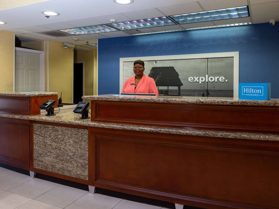 A hotel reception desk with a large framed picture of a sailboat and the word "explore."