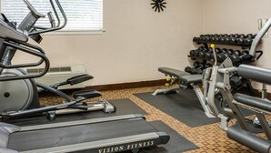 A gym with treadmills, a bench press, and a rack of dumbbells. - Suburban Studios Avondale (Westwego)