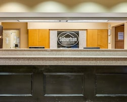 Un mostrador de recepción con un cartel del Hotel Suburban Extended Stay.