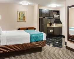 Una habitación de hotel con cama, kitchenette y baño.