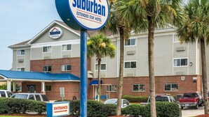 A Suburban Extended Stay Hotel with a sign indicating the entrance direction. - Suburban Studios Avondale (Westwego)