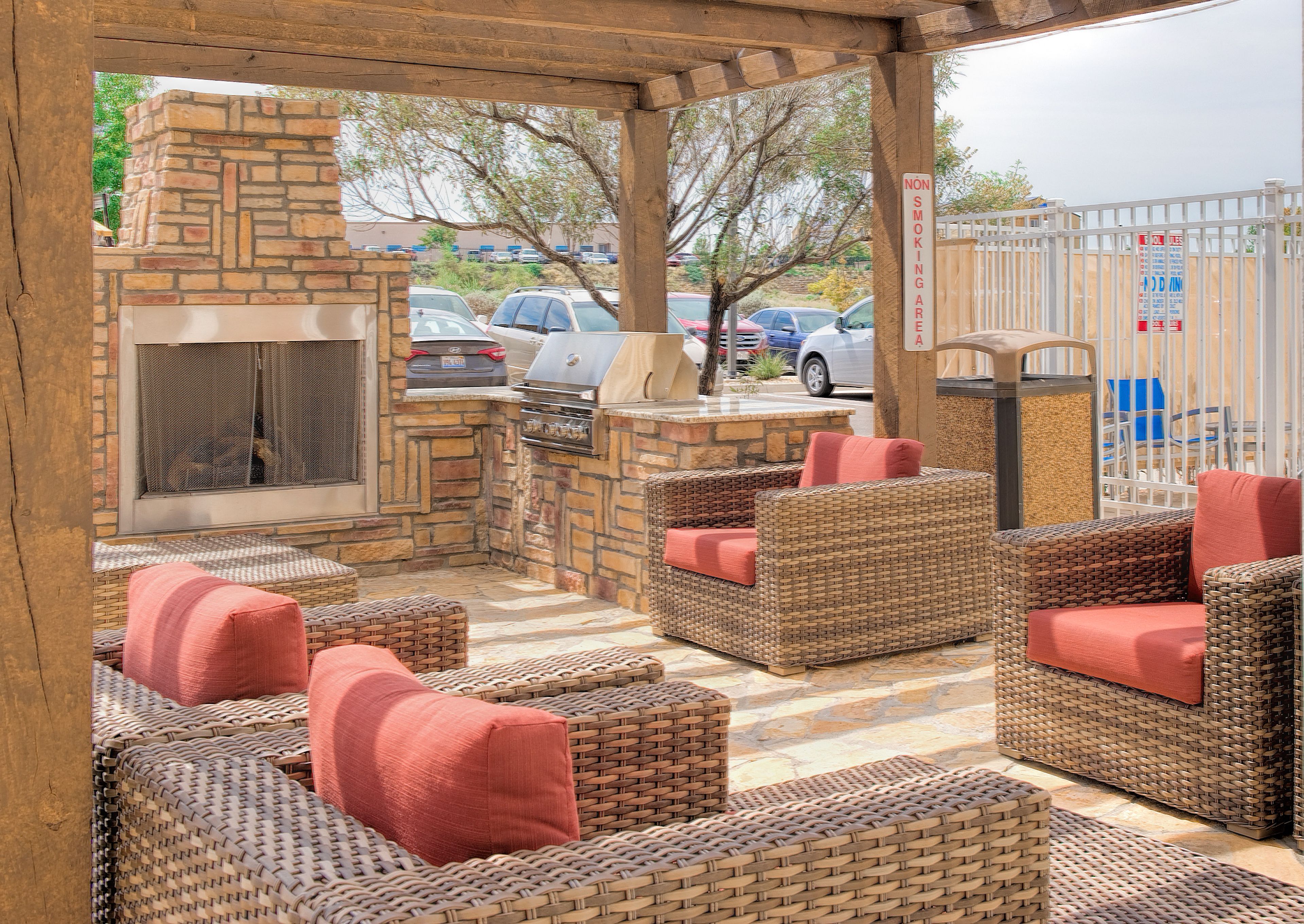 Une terrasse extérieure avec des meubles en osier et une cheminée en pierre.