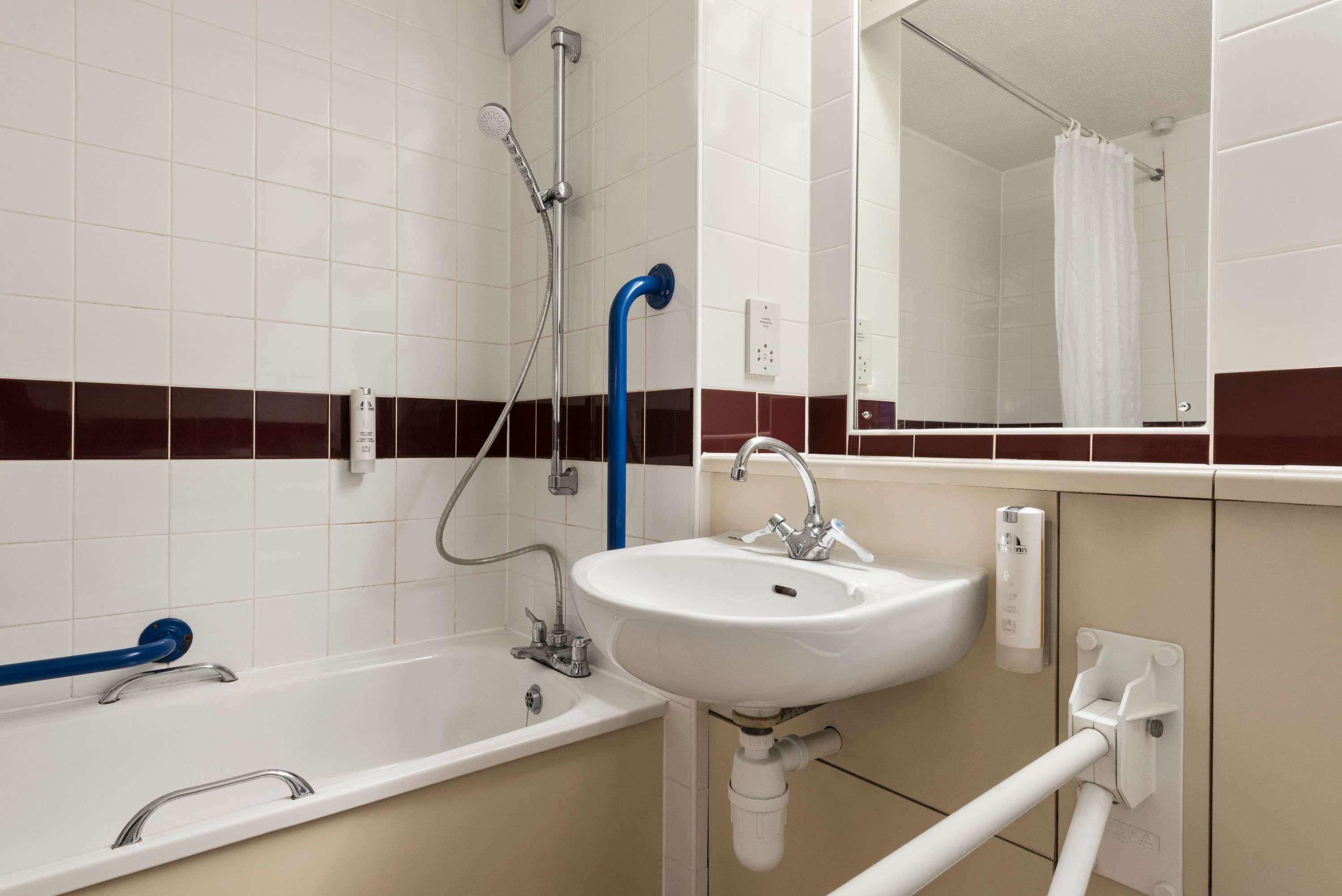 A bathroom with a white sink, a bathtub, and a shower.