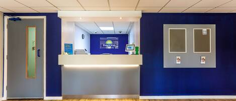 A reception area with a blue wall, a reception desk, and a wooden floor.