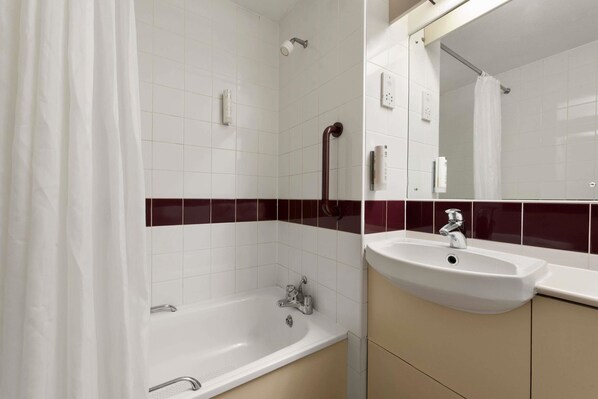 Un baño con bañera, lavamanos y espejo.