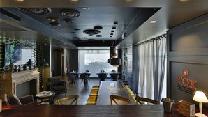A modern dining area with a long table, chairs, and a fireplace. - Elite Hotel & Spa (Mestre)