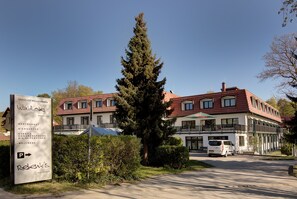 A hotel with a signboard listing amenities like a restaurant, beer garden, and wellness center. - Waldhotel Wandlitz (Wandlitz)