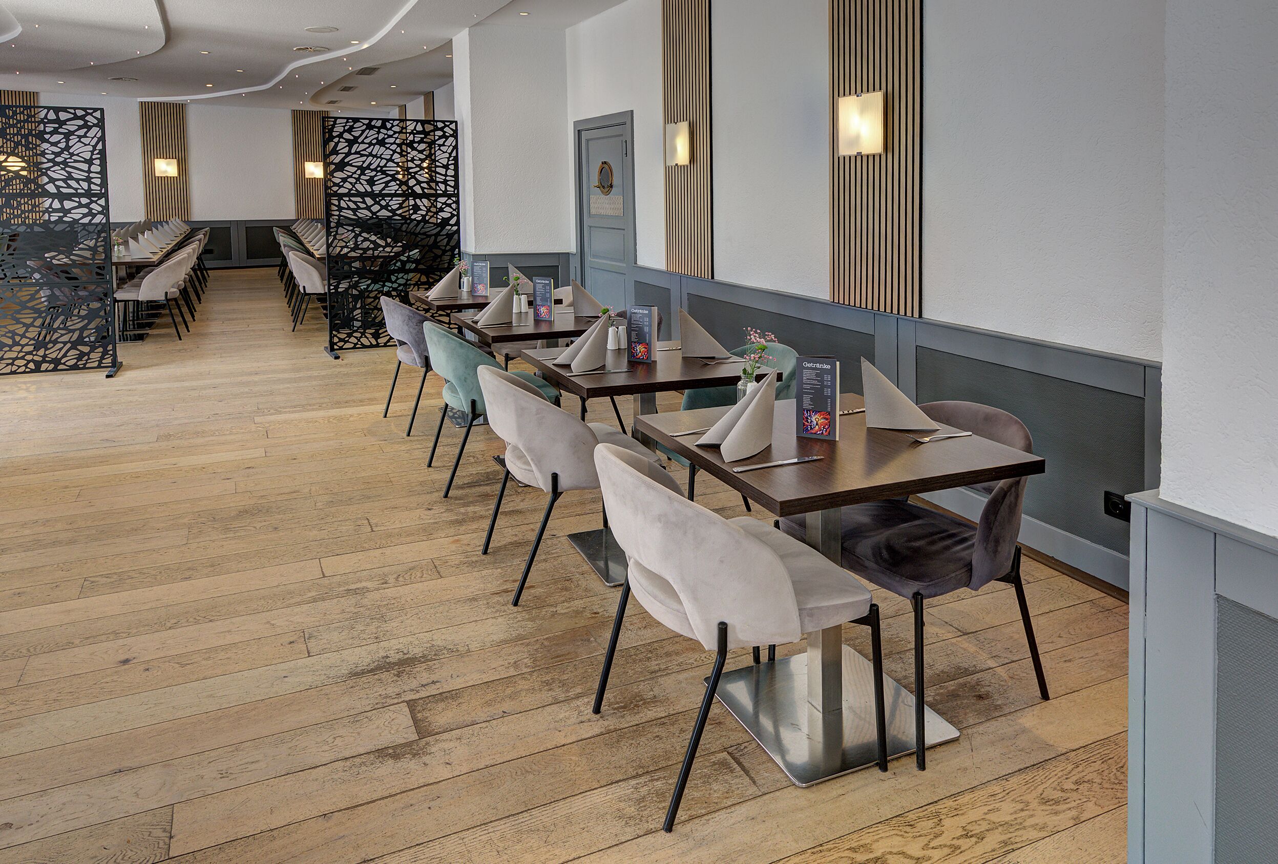 Een restaurant met houten vloeren, moderne stoelen en tafels.