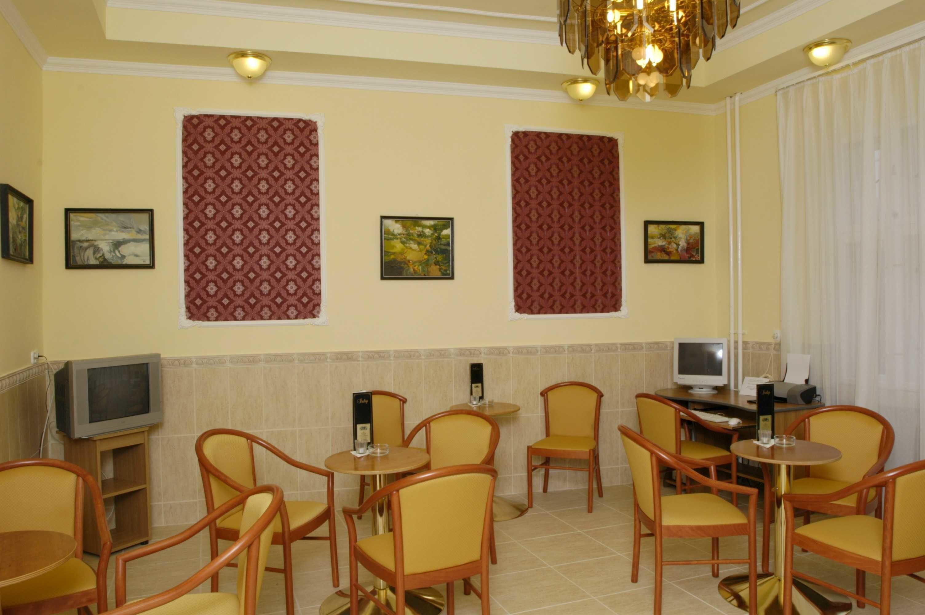 Habitación de hotel con comedor, dos televisores y varias sillas.