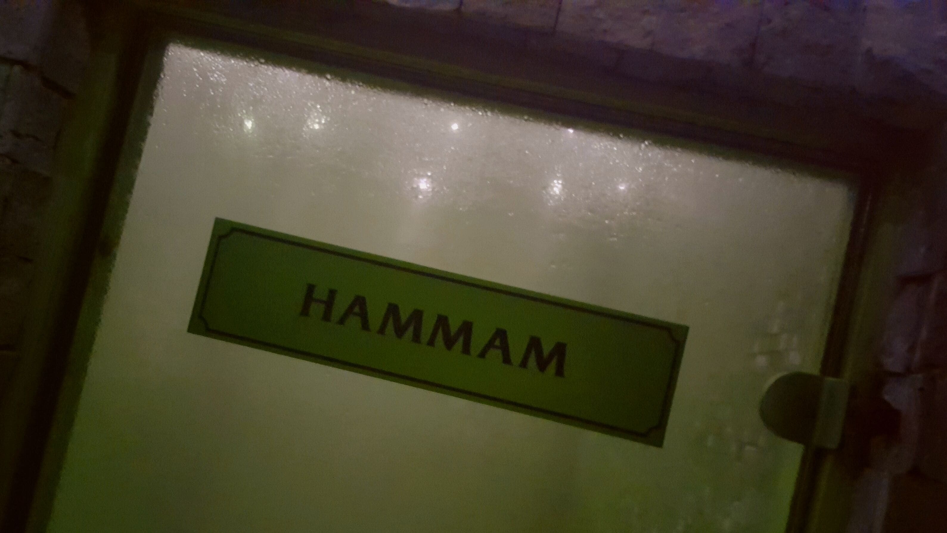 Una puerta con una placa que dice "HAMMAM".