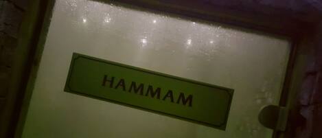 Une porte avec une plaque indiquant le nom « HAMMAM ».