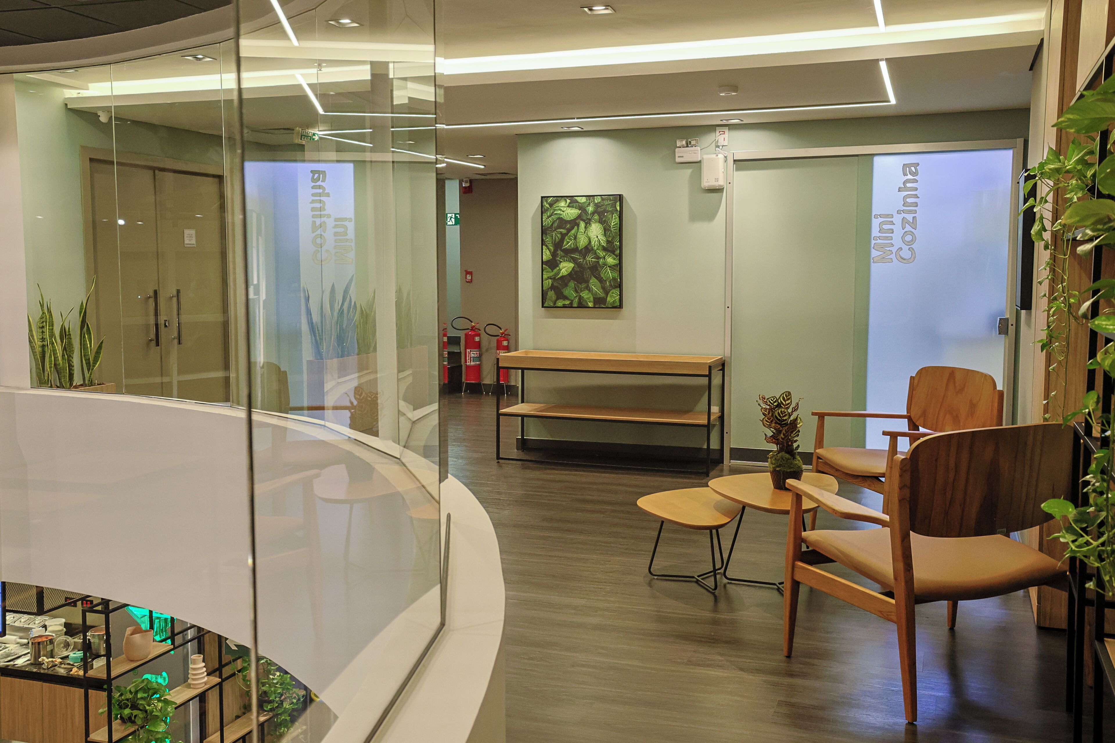 A modern interior with a curved glass partition, wooden furniture, and a fire extinguisher mounted on the wall.