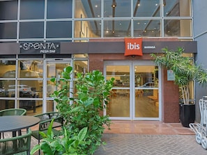 A building with a storefront named 'SPONTA' and 'ibis' across the entrance.