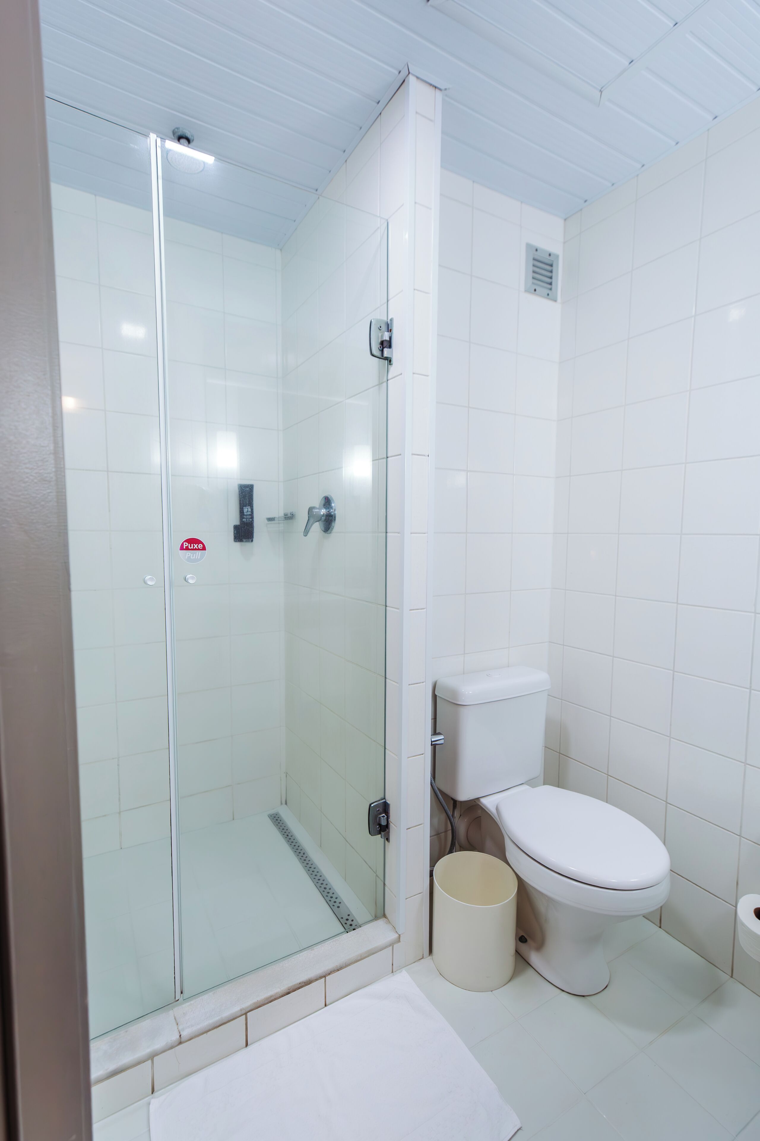 A bathroom with a glass-enclosed shower, a toilet, and a bidet.