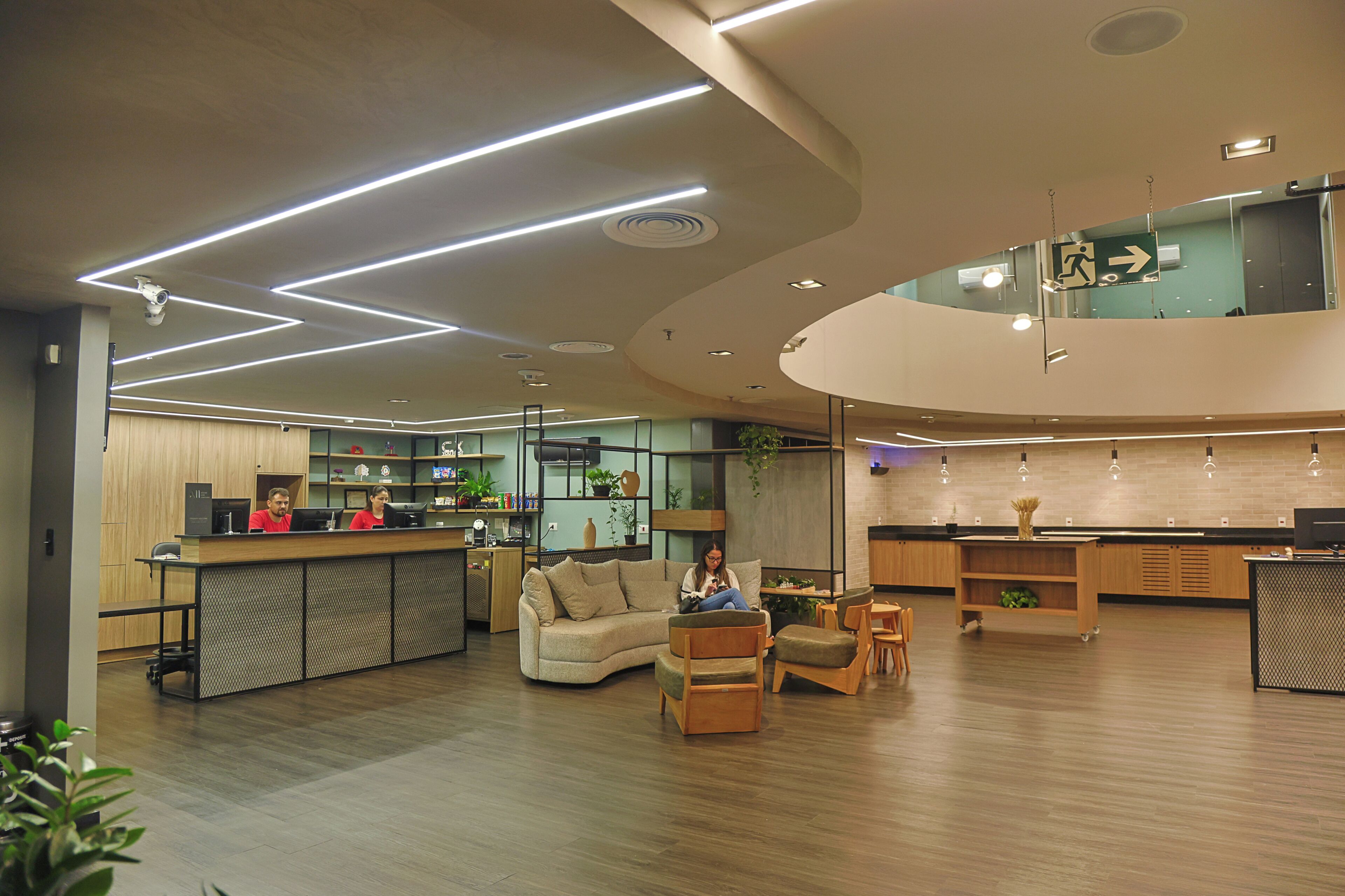 Un interior moderno con un mostrador de recepción, zona de estar y cocina.