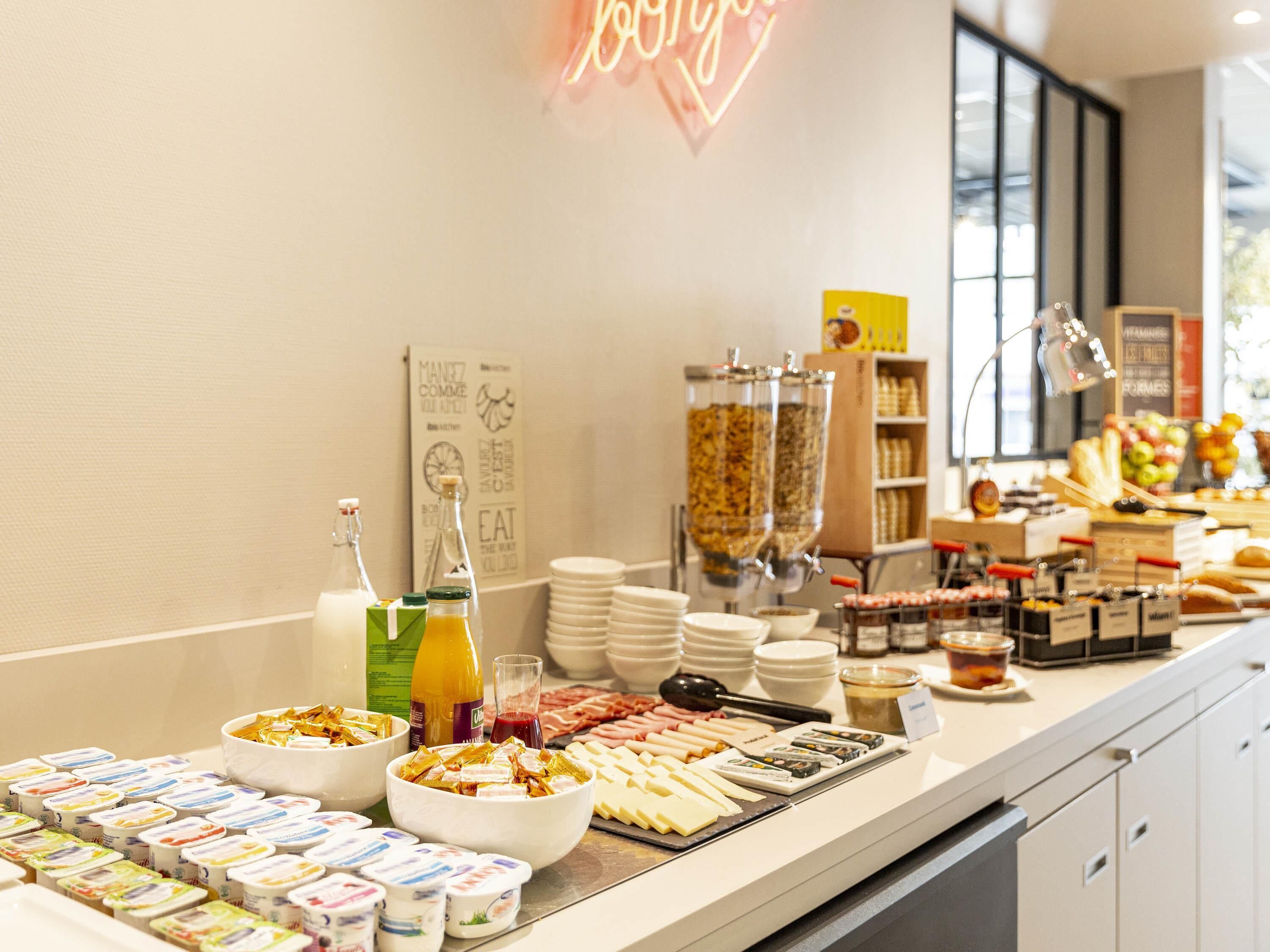 Un buffet proposant une variété de plats, notamment des fromages, des viandes et des condiments.