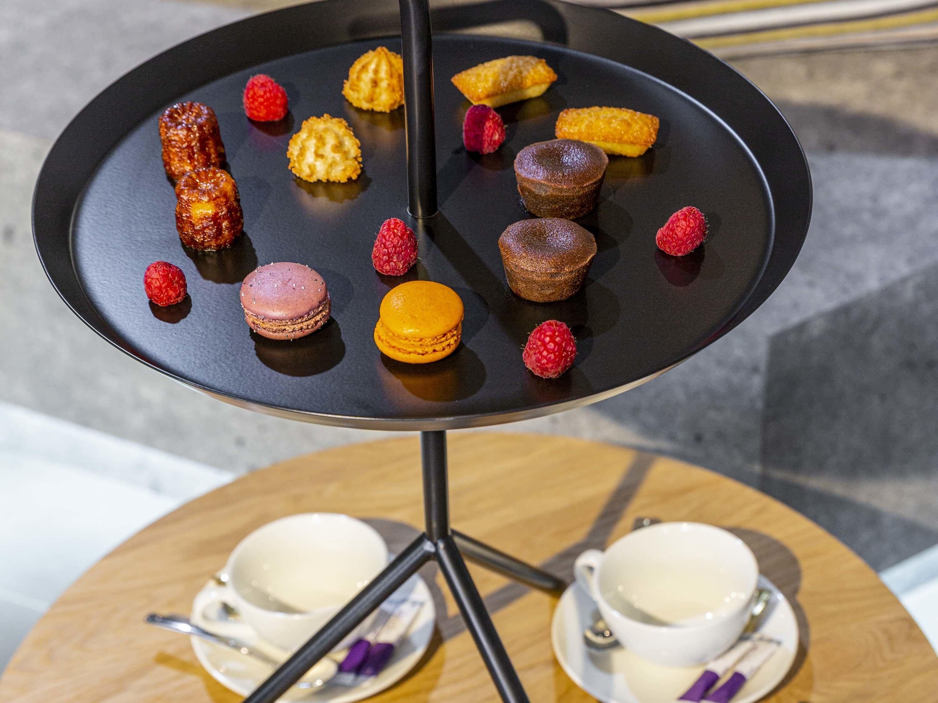 A dessert plate with various pastries and a coffee setup on a table.