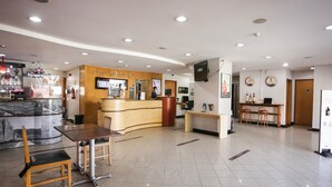 A hotel lobby with a reception desk, a bar area, and seating arrangements. - Ibis Teresina (Teresina)