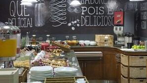 A buffet area with a chalkboard menu, various food items, and a coffee machine. - Ibis Teresina (Teresina)