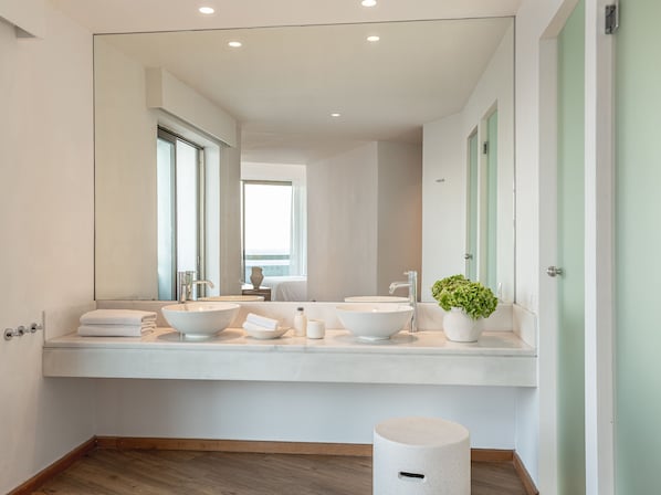 A modern bathroom with two sinks, a large mirror, and a potted plant. - Grecotel LUX ME Dama Dama (Rhodes)