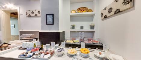 A buffet setup with various food items and utensils.