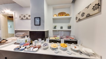 A buffet setup with various food items and utensils.