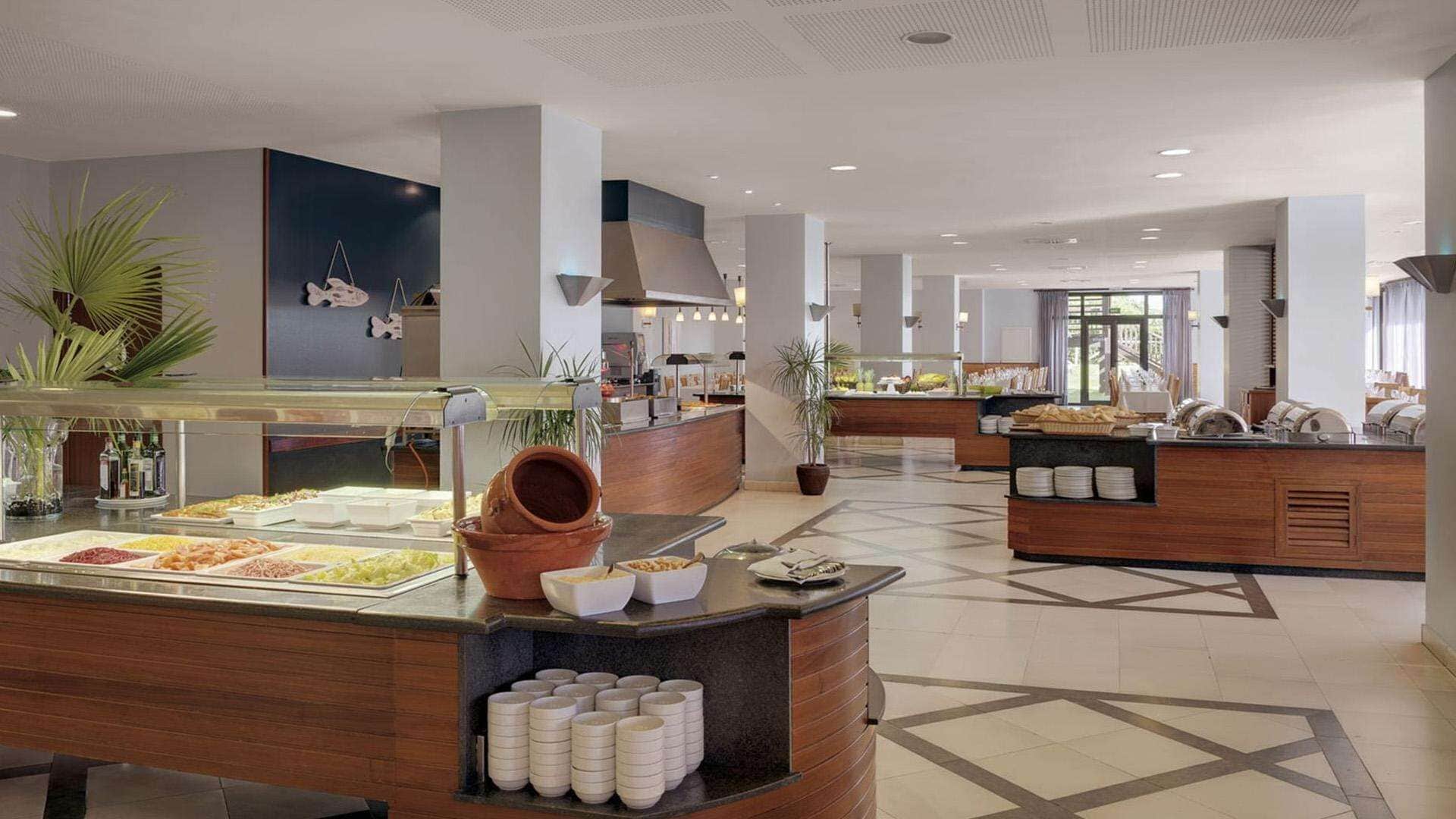 A modern buffet area with various food stations, including a salad bar and a hot food section.