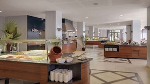 A modern buffet area with various food stations, including a salad bar and a hot food section.