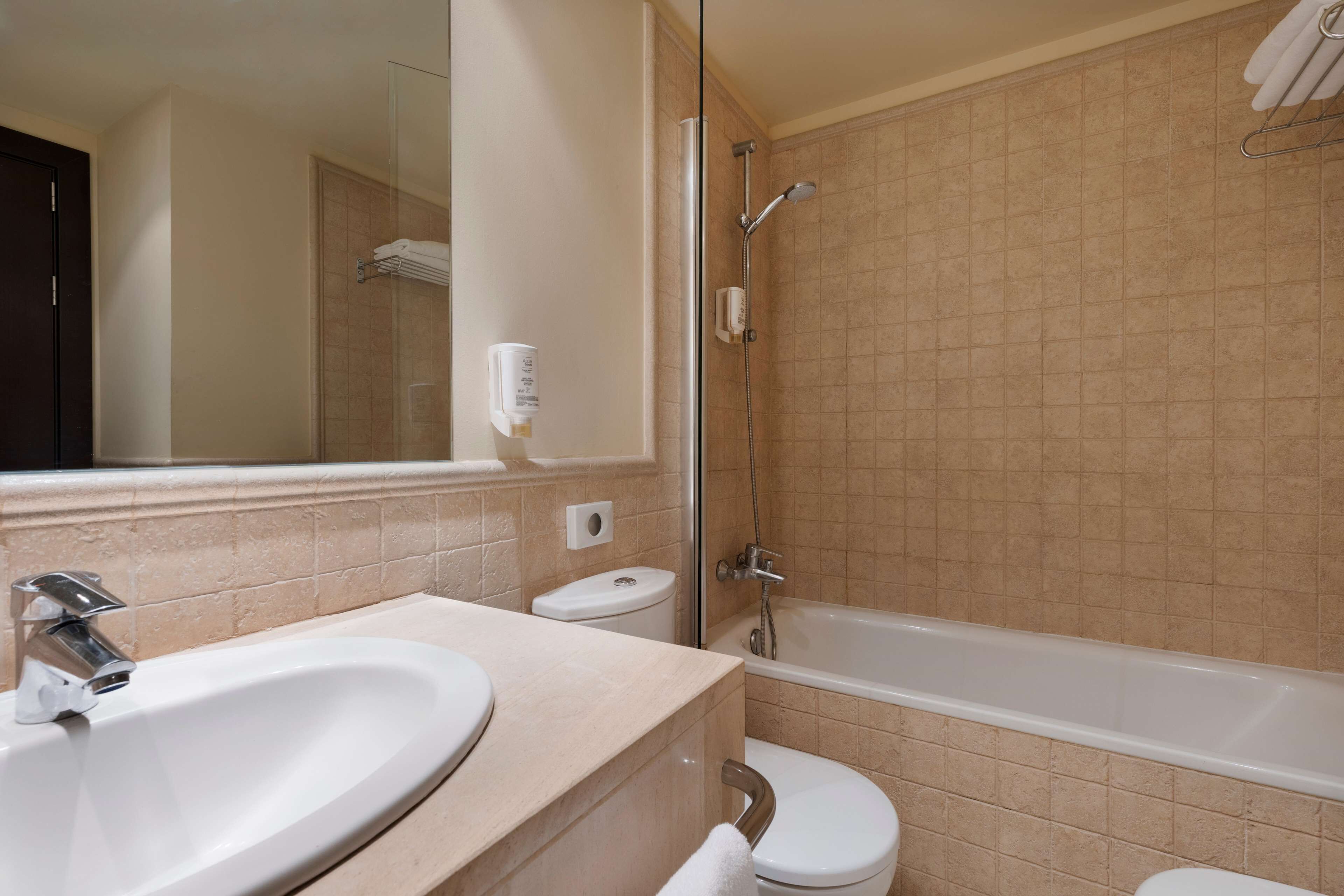 A bathroom with a sink, toilet, and bathtub.