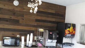 Eine Küche mit Mikrowelle, Kaffeemaschine und einer Fruchtsaftmaschine.