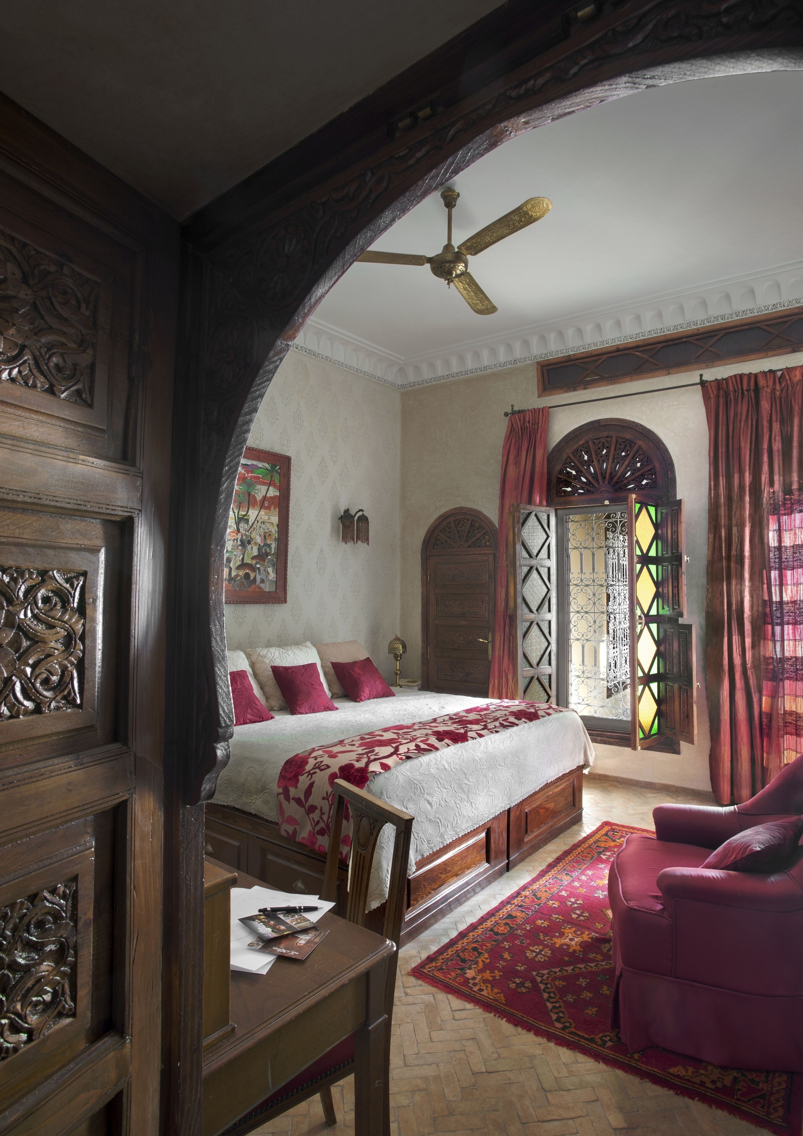 A traditional bedroom with a bed, a desk, and a chair.