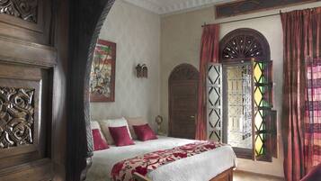A traditional bedroom with a bed, a desk, and a chair.