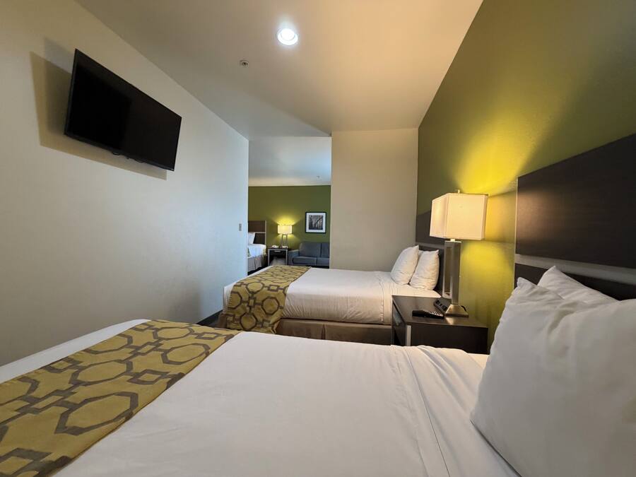 Een hotelkamer met twee bedden, een televisie, een lamp en een bureau.