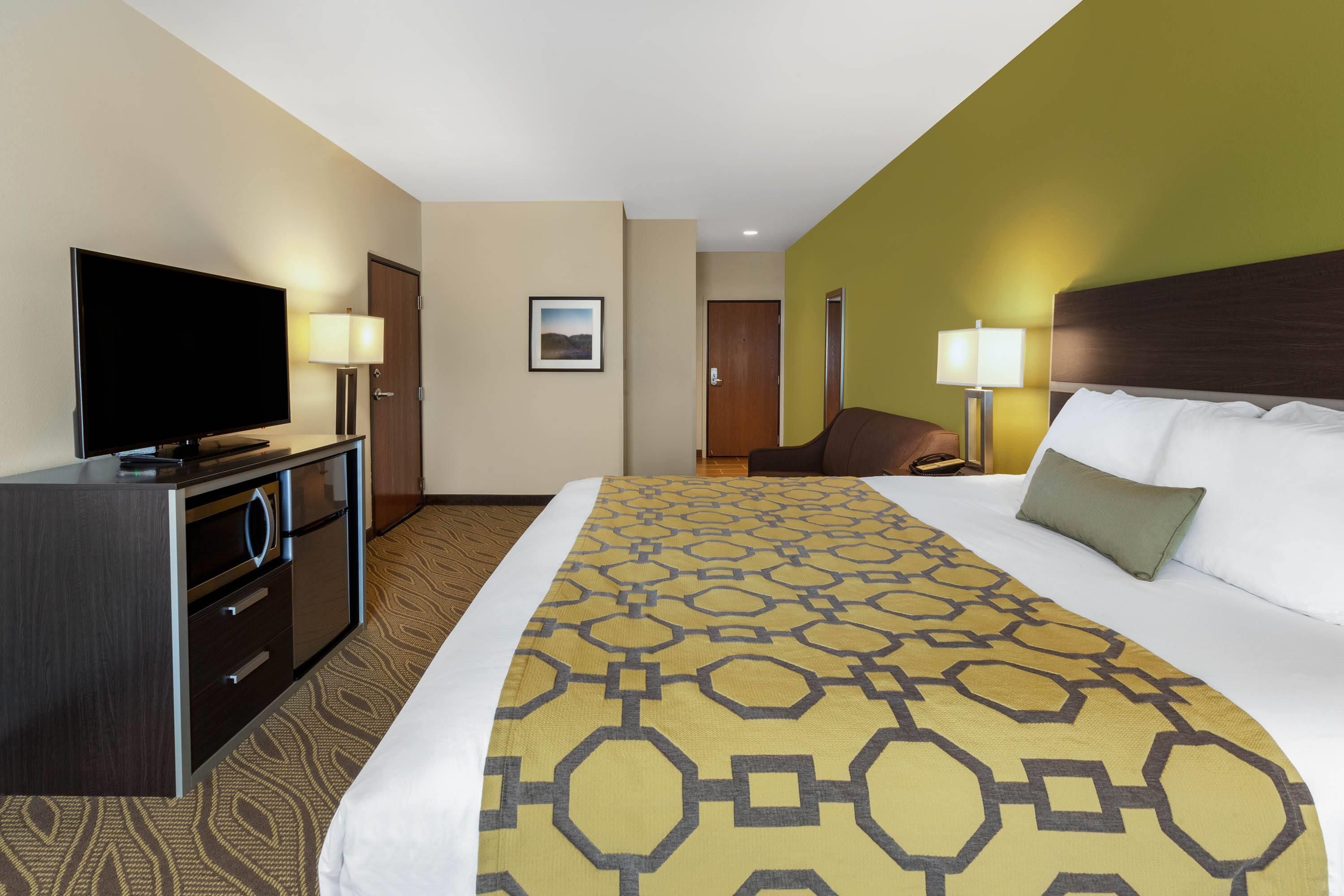 A hotel room with a bed, a television, a desk, and a chair.