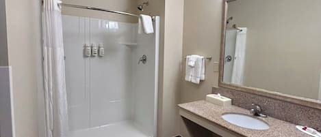 A modern bathroom with a glass-enclosed shower, a sink with a mirror, and a vanity.