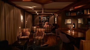 A cozy, dimly lit room with a wooden ceiling, plush seating, and a bar area. - Hotel Ambiance  (Zermatt)