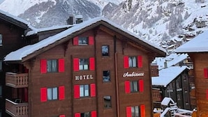 A hotel with a prominent mountain peak in the background. - Hotel Ambiance  (Zermatt)