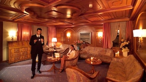 A luxurious hotel lobby with a wooden ceiling, plush seating, and ambient lighting.