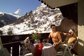 Un couple dînant sur un balcon avec vue sur les montagnes.