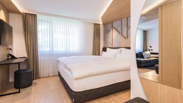 Una habitación de hotel moderna con una cama grande, un escritorio y un televisor.