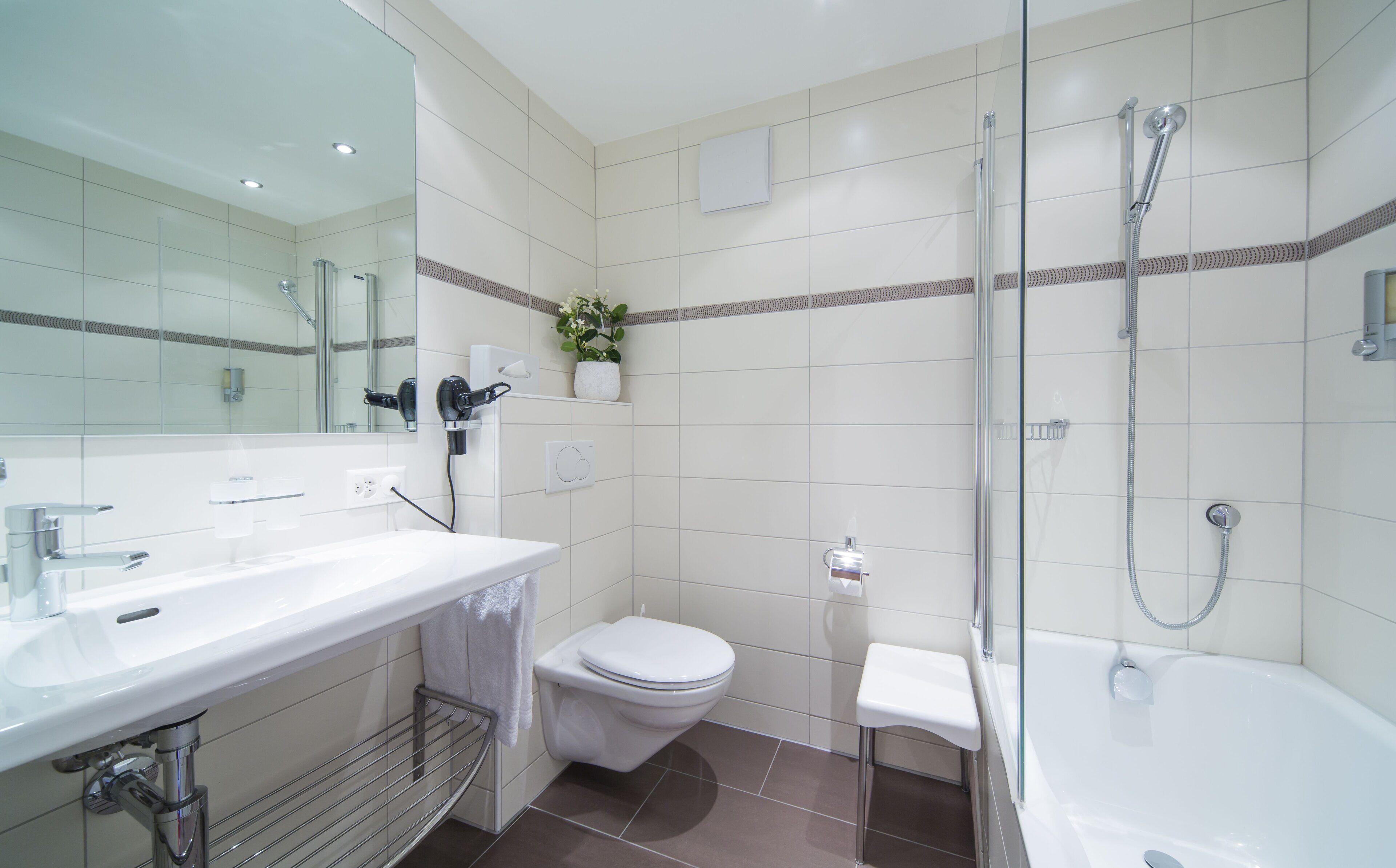 Un bagno moderno con lavandino, water e vasca da bagno bianchi.