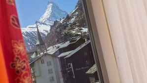 A mountain with a church and a building labeled "Dent-Blanche" in the background. - Hotel Excelsior (Zermatt)