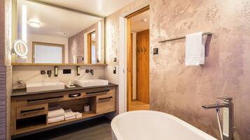 A modern bathroom with a freestanding bathtub, wooden vanity, and a large mirror.