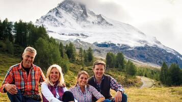 Un grupo de personas sentadas sobre la hierba, con una montaña al fondo.