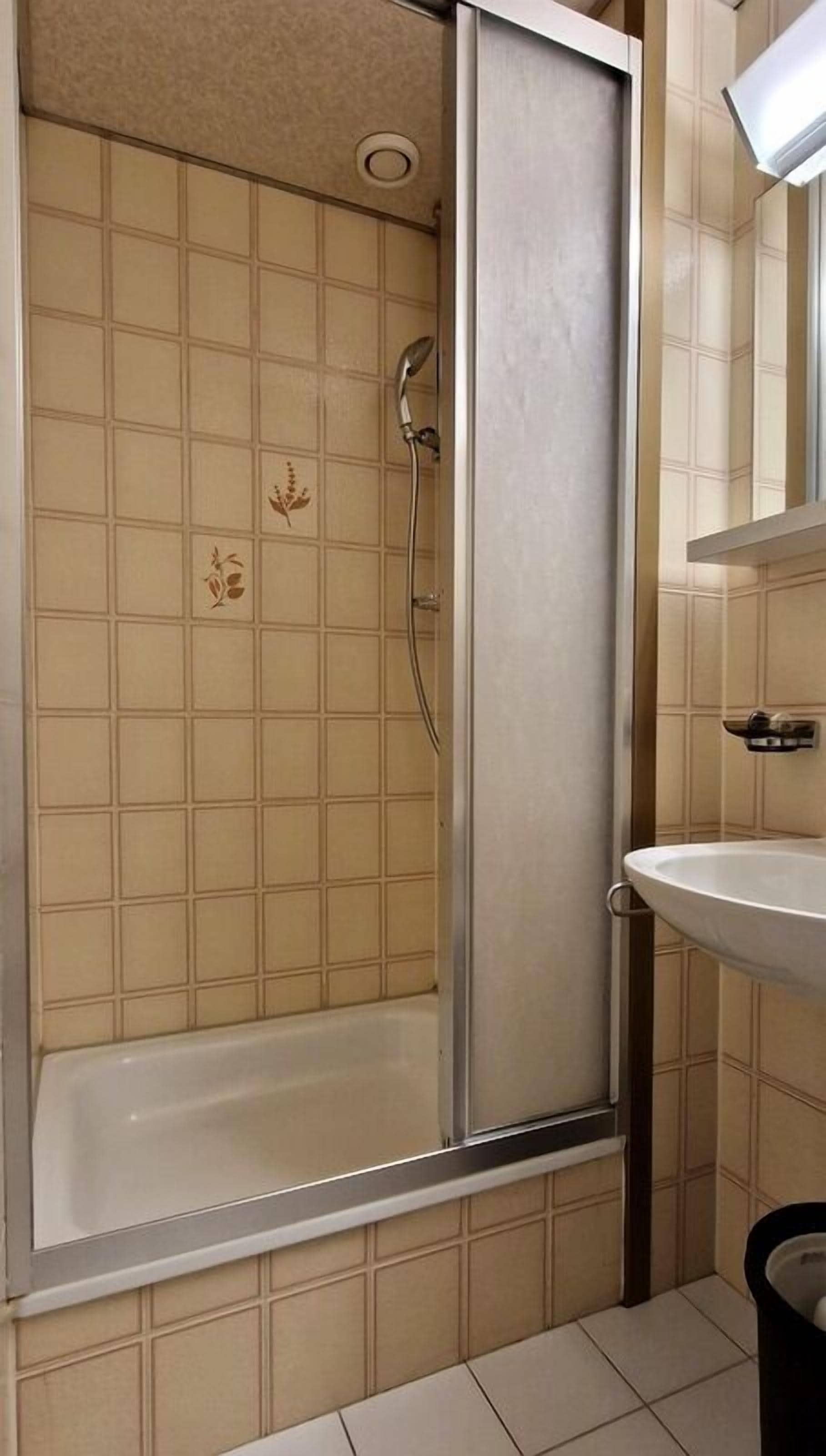 Un bagno con doccia a pavimento, vasca e lavabo.