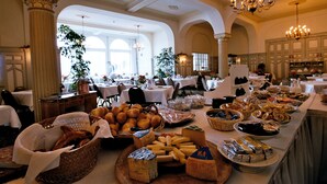 Ein Buffet mit verschiedenen Speisen und ein Sitzbereich mit Tischen und Stühlen.